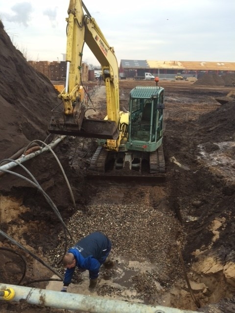 Gravemaskine udfører drænarbejde med nedlægning af rør i Ribe